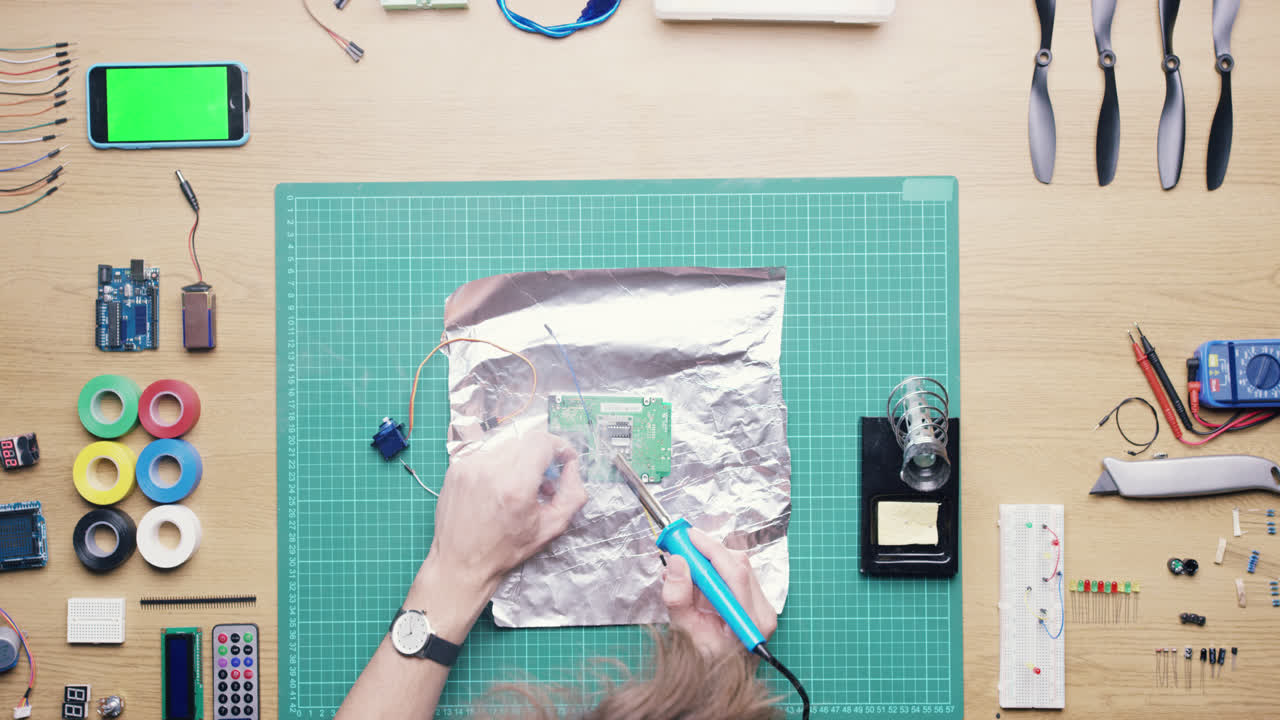 vista superior técnico de soldadura de placa de circuito trabajando en el escritorio desde arriba - dragón épico rojo