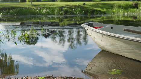 single rowboat on a calm river with water moving slowly on a sunny summer day