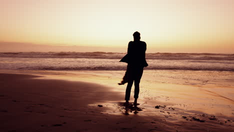 Beach,-sunset-and-dad-spinning-child