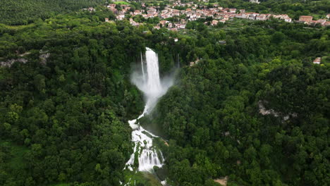 Cascada-Artificial-Marmore-Cae-Con-Niebla,-Rodeada-De-Un-Exuberante-Bosque-Verde-En-Umbría,-Italia