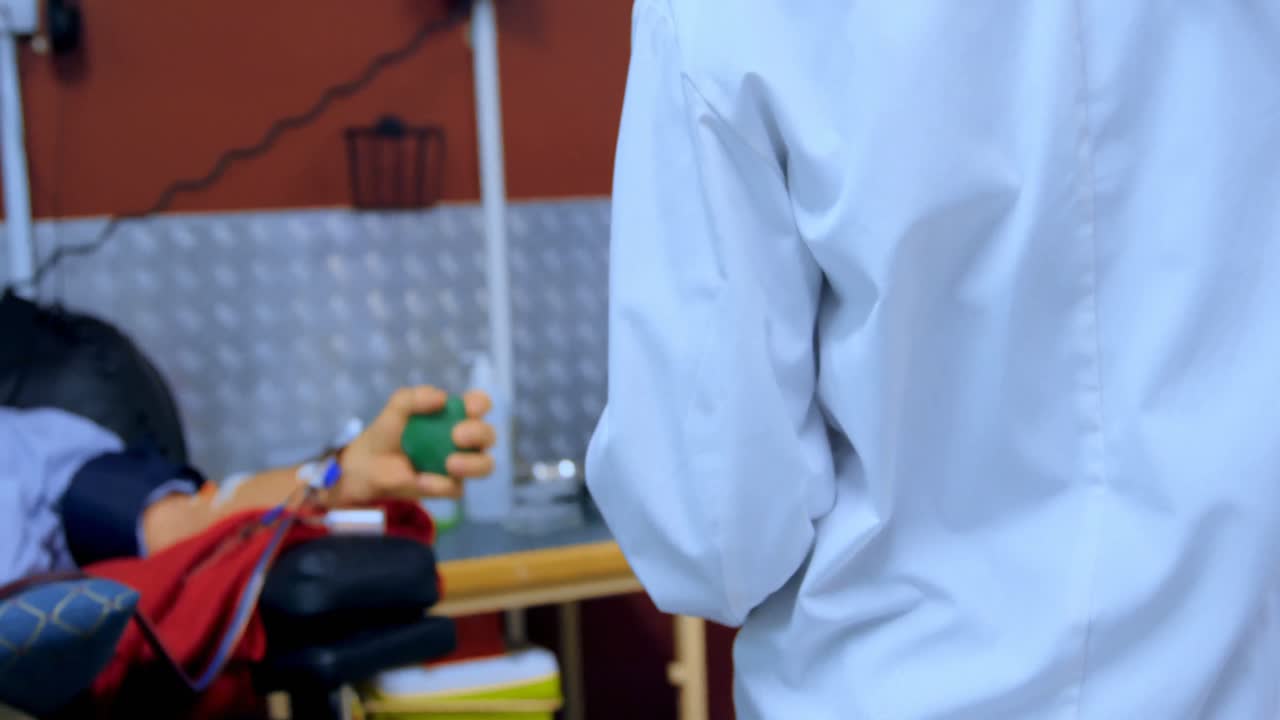 médico chequeando hombre mayor donando sangre 4k