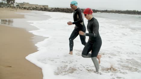 happy man and woman running on beach