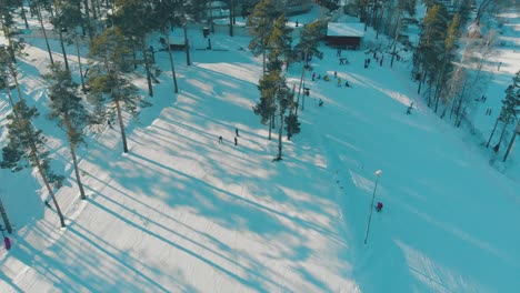 skiers go down hill track at popular winter resort aerial