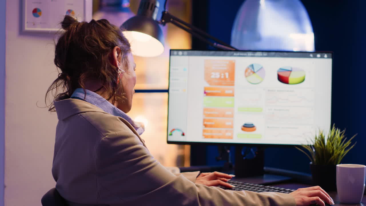 Woman working with charts on computer at desk