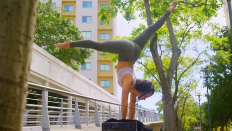 joven bailarina practicando el handstand en el banco 4k