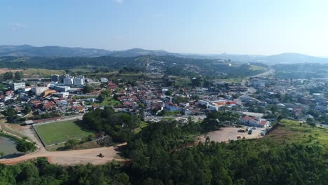 Plan-with-Drone-in-lateral-movement-of-small-town-in-the-interior-of-São-Paulo,-small-houses-and-beautiful-countryside-landscape-in-the-background,-in-4K-resolution