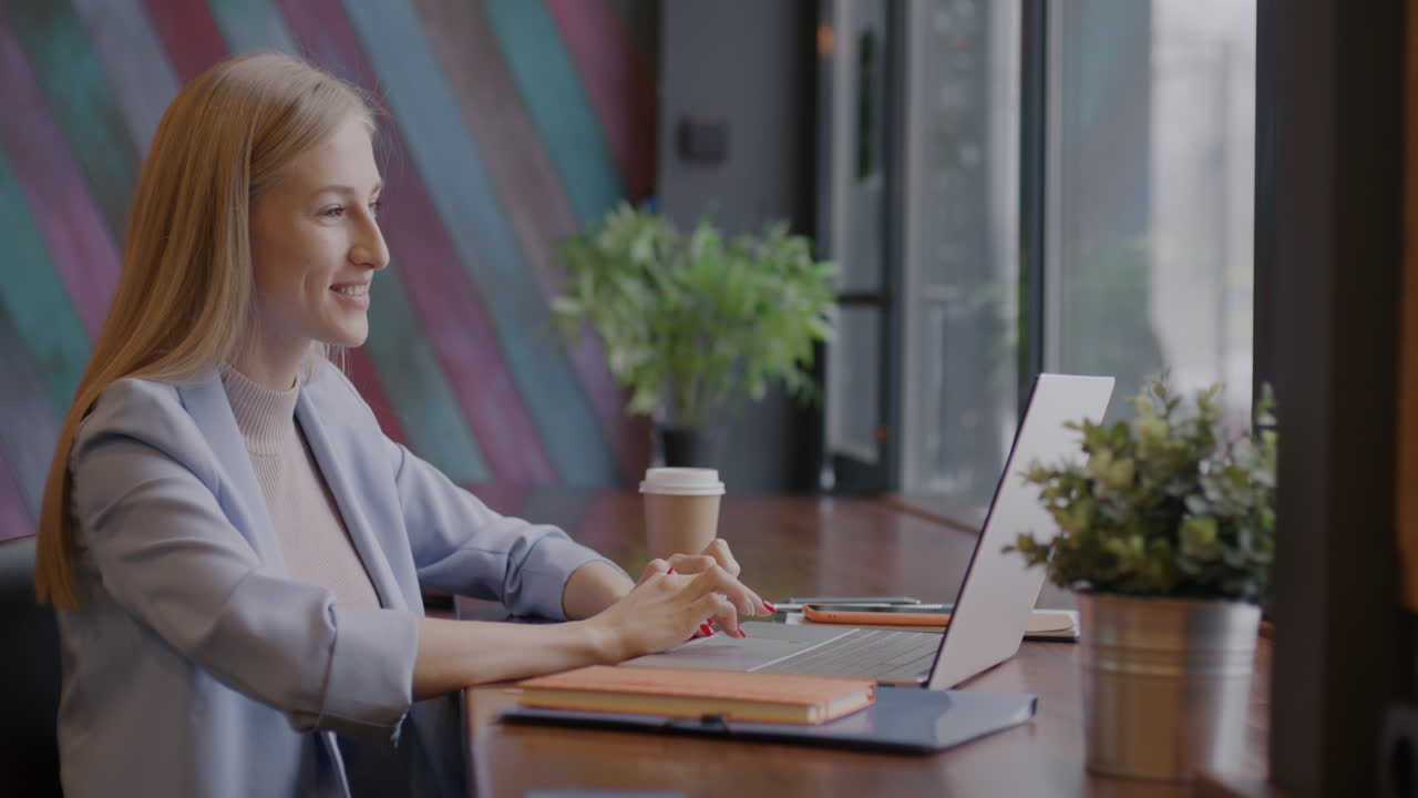 Donna d'affari che lavora al portatile in un caffè