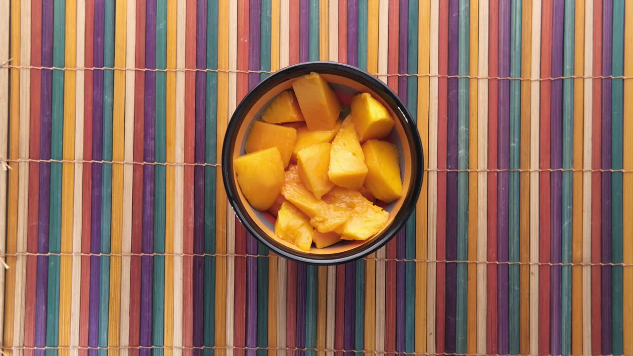 comiendo mango con la mano de un cuenco