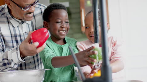 Glückliche-Afroamerikanische-Großeltern-Und-Enkelkinder-Beim-Gemüsewaschen-In-Der-Küche,-Zeitlupe