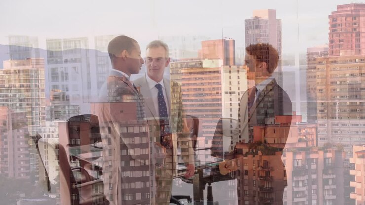 Composizione digitale di diversi uomini d'affari che si stringono la mano in ufficio, sullo sfondo di una vista aerea dello skyline cittadino.