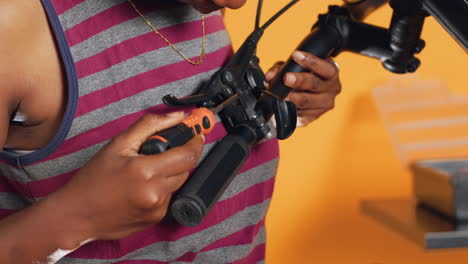 Woman-uses-screwdriver-to-secure-brake-levers-on-handlebars,-close-up