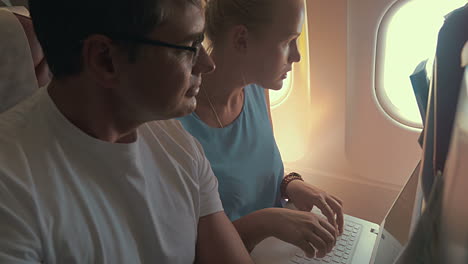 young people working with laptop in plane