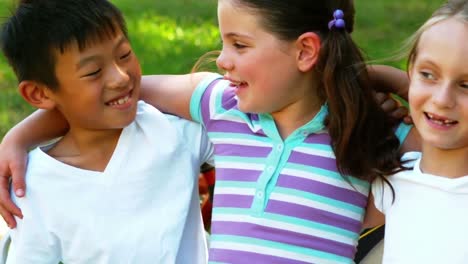 niños de pie juntos con el brazo alrededor en el parque
