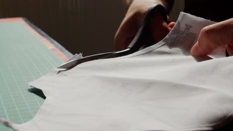 female hands cut around a sewed shape of fabric