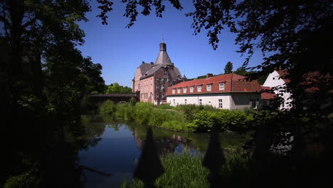 Castle-Aldenghoor-in-Haelen,-Limburg,-The-Netherlands,-with-iron-fence-on-foreground