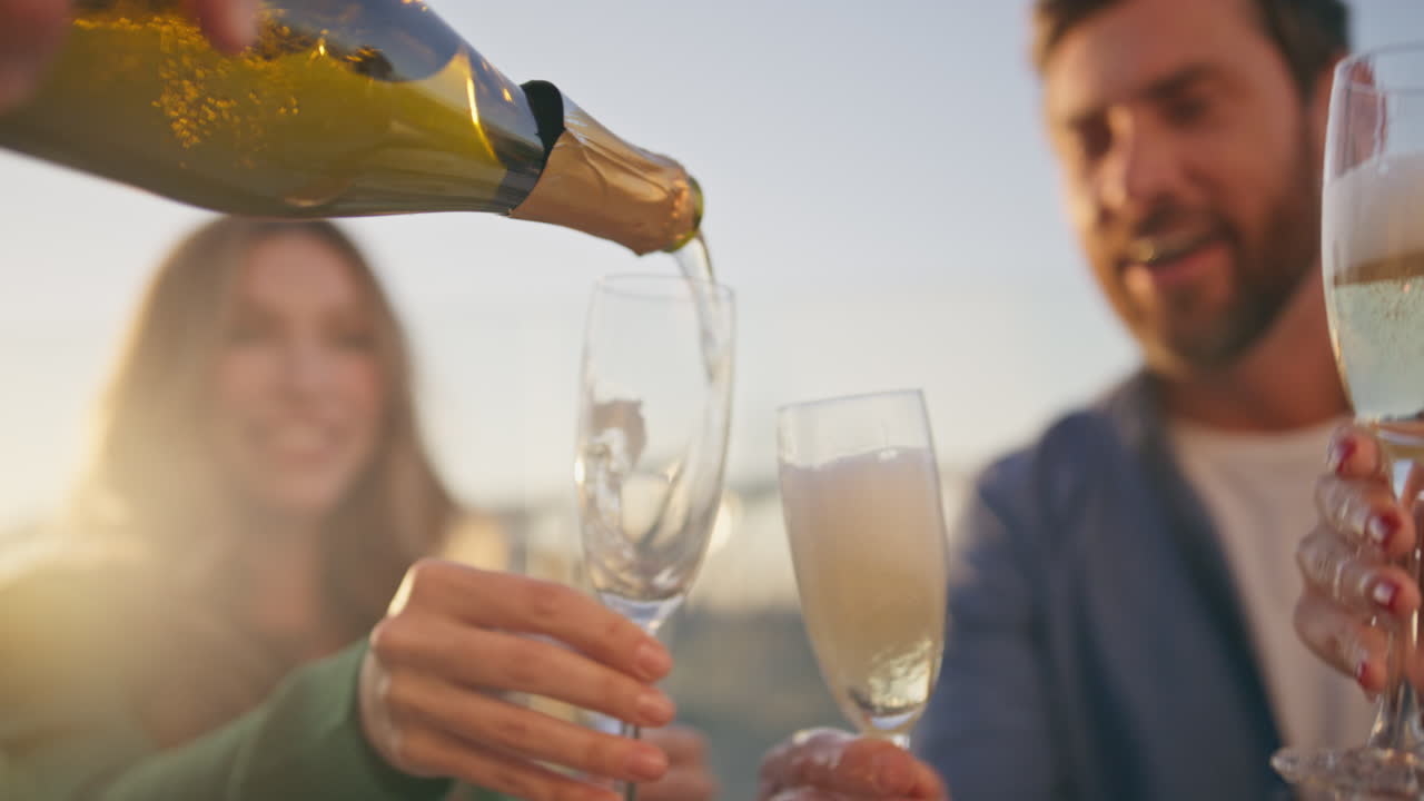 colegas vertiendo vino espumoso en copas disfrutando del tiempo juntos de cerca.