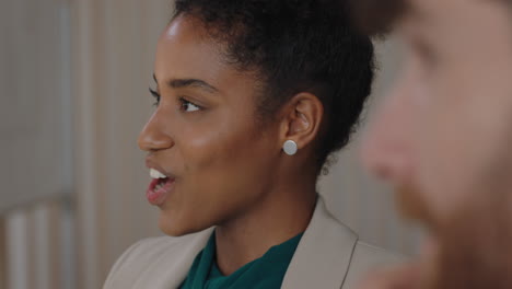 happy african american business woman chatting to colleague laughing having fun in office meeting enjoying connection