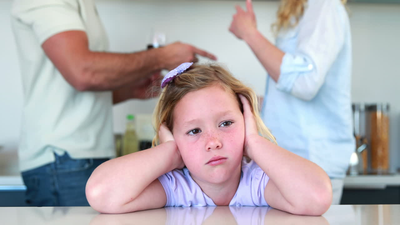 Little girl blocking out noise from parents fighting