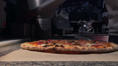 imágenes de un cocinero cortando pizza en un restaurante italiano ubicado en grecia