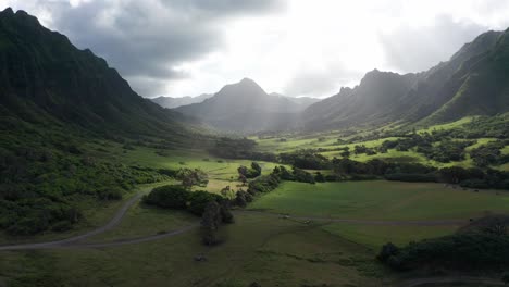 Toma-Aérea-Baja-Del-Icónico-Valle-Jurásico-Con-La-Hermosa-Luz-Del-Sol-Brillando-A-Través-De-Las-Nubes-En-La-Isla-De-O&#39;ahu,-Hawaii