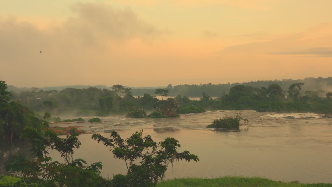 Tidlig morgensolopgang ved Murchison Falls, Uganda, hvor blødt lys afslører hurtigtstrømmende Nil-vand, der skaber et dramatisk og fredfyldt naturlandskab i Afrika.