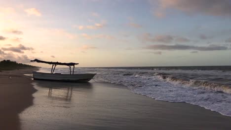 small fishing boat on a sandy caribbean sea beach during sunset