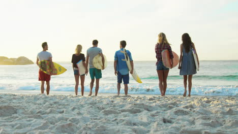 Grupo-De-Amigos-Sosteniendo-Tabla-De-Surf