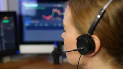 A-female-customer-support-agent-talking-through-a-headset-microphone-in-an-office