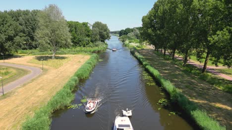 Aerial-drone-shot-above-a-nature-park,-water-canal-with-boats,-of-Almere-city,-province-Flevoland,-Netherlands