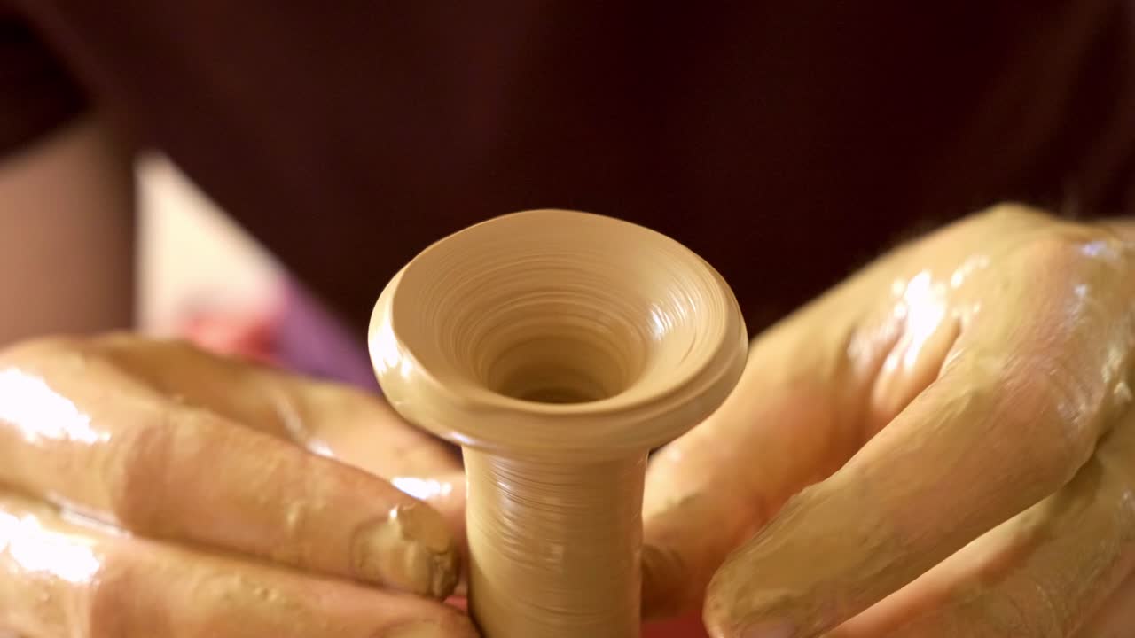 Craftsmanship in Motion: A Skilled Artisan Shapes a Beautiful Ceramic Vessel on a Pottery Wheel, Showcasing the Art of Clay Manipulation and Creativity