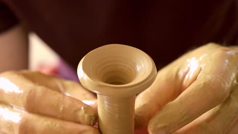craftsmanship in motion: a skilled artisan shapes a beautiful ceramic vessel on a pottery wheel, showcasing the art of clay manipulation and creativity