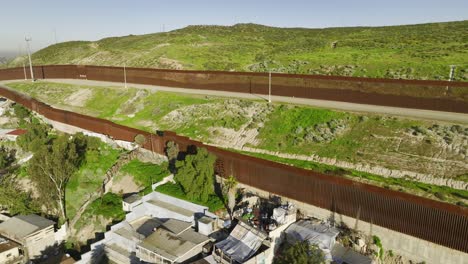 Flying-close-to-the-Mexican---US-border-wall-in-Tijuana,-Mexico---Aerial-view