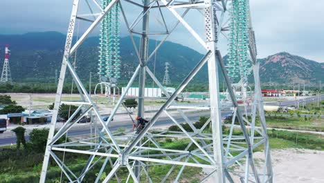 aerial drone footage of high-voltage power towers with prefabricated glass insulators to distribute electricity in an industrial park - development and urbanization concept