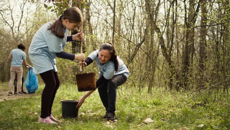 mother and daughter team up to plant new trees in the woods