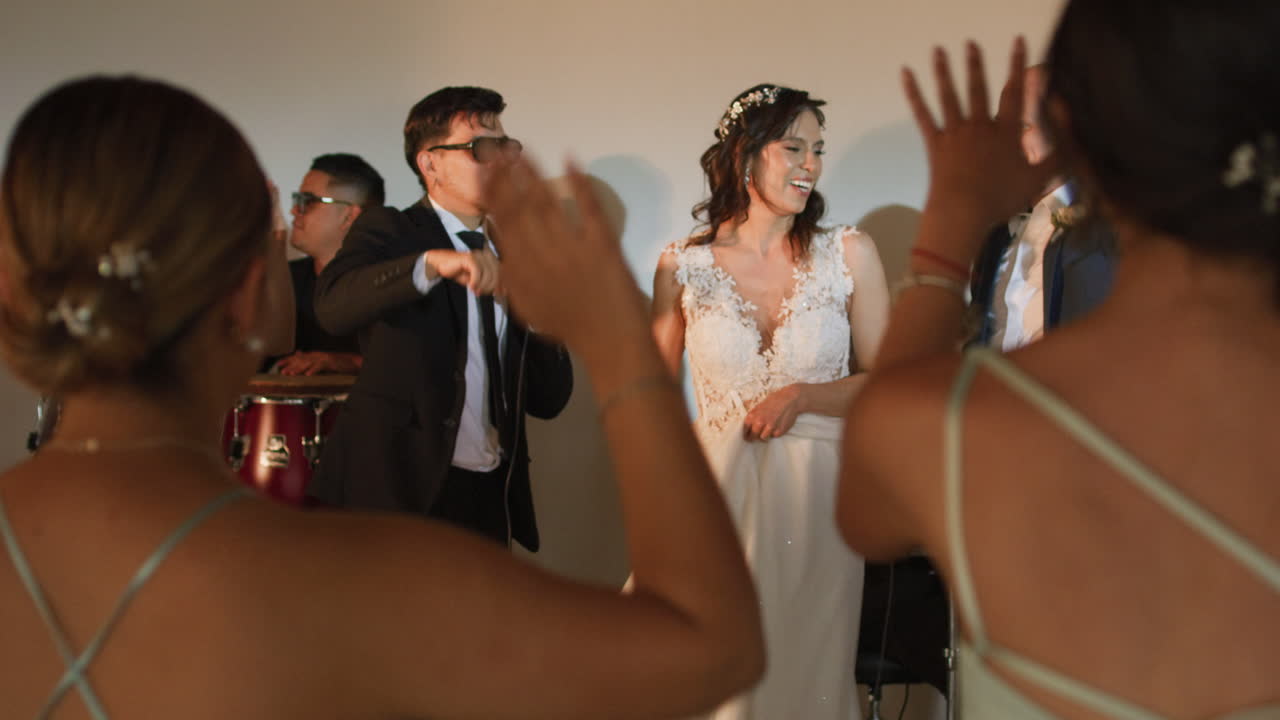 Clip of a wedding where the newlyweds dance happily with their guests and bridesmaids.