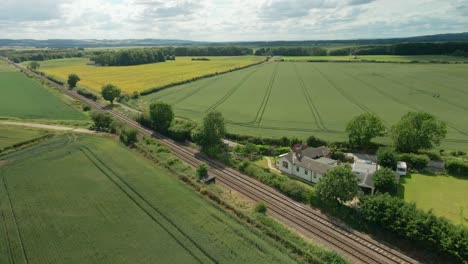 Vista-Aérea-De-La-Escena-Rural-Británica-Con-Vías-De-Tren,-Tierras-Agrícolas-Y-Campos-Verdes