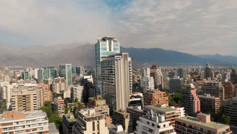 flying over the city closing on skyscraper on a sunny day, santiago chile-4k