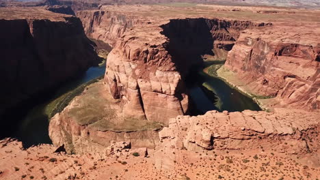 Toma-Aérea-De-Turistas-Visitando-Los-Acantilados-De-La-Curva-De-La-Herradura-En-Arizona,-Destino-Turístico