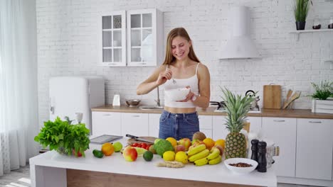 woman with fresh salad in the kitchen. attractive girl eating organic food at home. beautiful housewife cooking salad. healthy lifestyle.