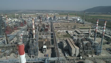 imágenes aéreas de una refinería de petróleo a gran escala con pilas de humo y tanques de almacenamiento de petróleo