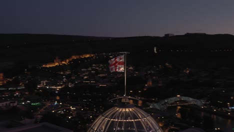 aerial pan shot circular of holy trinity church in night, tbilisi