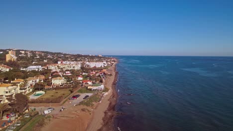 Vista-Aérea-De-La-Costa-De-España,-Moviéndose-Hacia-Atrás-Y-Más-Cerca-De-La-Playa