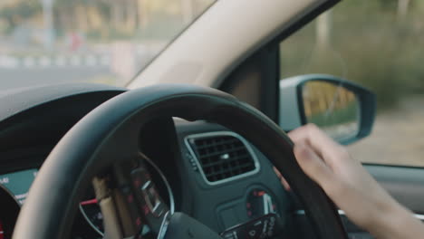 Mujer-Conduciendo-Un-Automóvil-Con-Las-Manos-En-El-Volante-Para-Controlar-El-Vehículo-En-La-Ciudad-Viajando-Por-La-Carretera-En-Hora-Punta-Hacia-El-Destino.