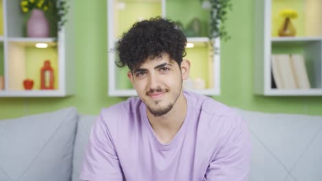 young man looking at camera and laughing. positive expression.