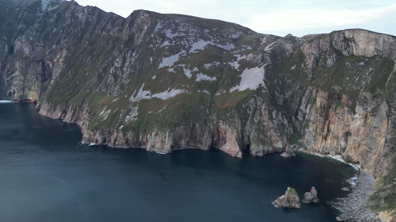 video de un avión no tripulado volando hacia atrás desde slieve league, irlanda al atardecer