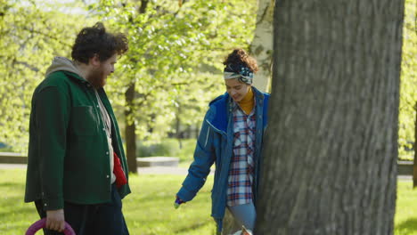 couple walks their dogs in a sunny park