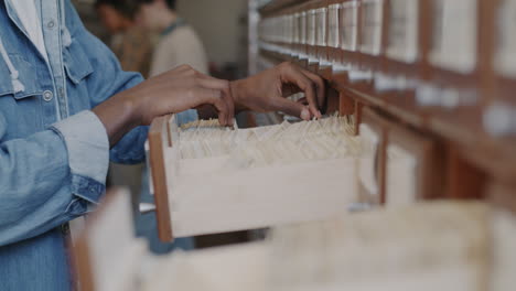 person filing documents in a library cabinet