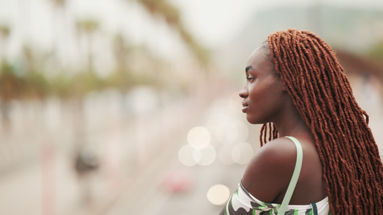 Donna con dreadlock che guarda il traffico cittadino