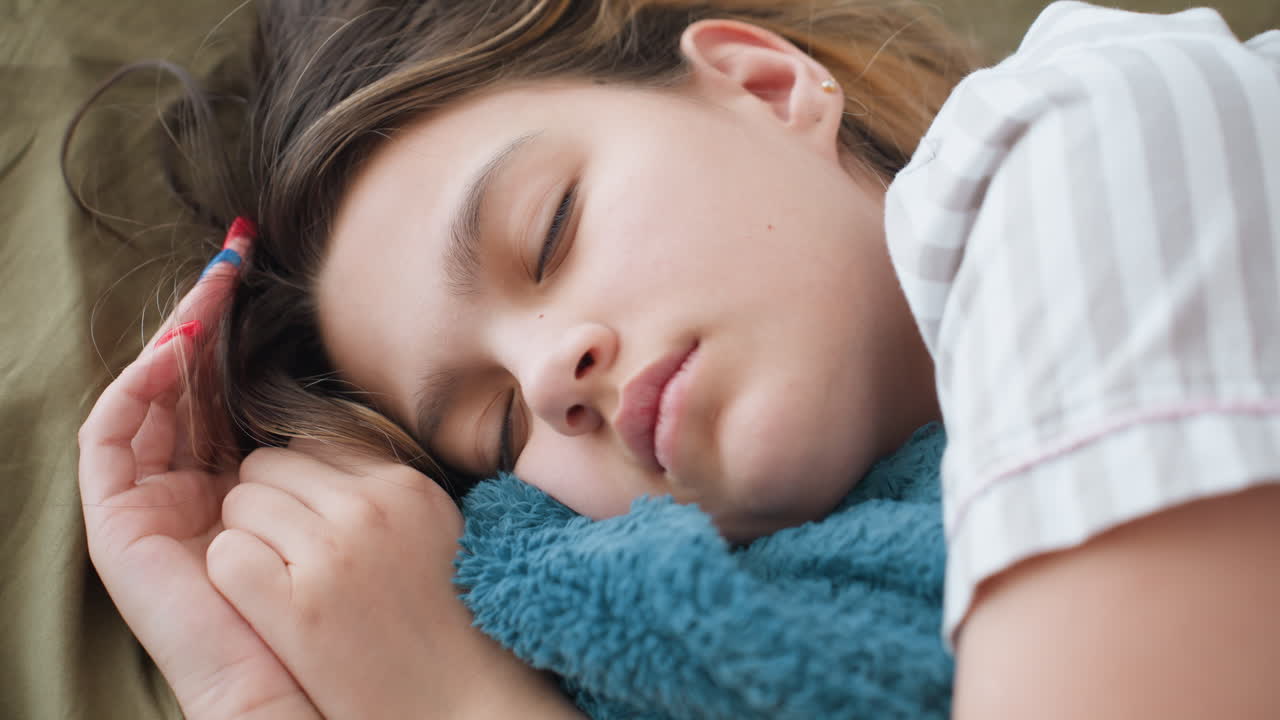 Sleeping White Girl Cuddling Teal Blanket, Peaceful Closeup Of Face And Hand, Soft Bedding And Relaxed Breathing, Home Nap Mood With Cozy Texture And Calm Atmosphere, Ideal For Wellness And Family
