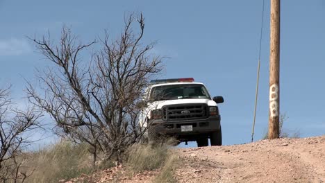 a border patrol vehicle is parked on a dirt road